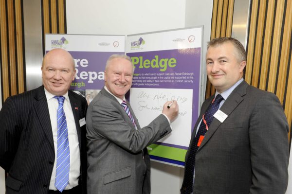 Care & Repair Edinburgh 30th Anniversary Scottish Parliament Event, 28/10/2015: Alex Neil MSP - the Cabinet Secretary for Social Justice, Communities and Pensioners' Rights (centre), signing the Care & Repair Edinburgh pledge board at the Scottish Parliament event. With him are Gordon McDonald MSP (left) and Care & Repair Edinburgh chief executive Graham Harper (right). Photography for Care & Repair Edinburgh from: Colin Hattersley Photography - colinhattersley@btinternet.com - www.colinhattersley.com - 07974 957 388