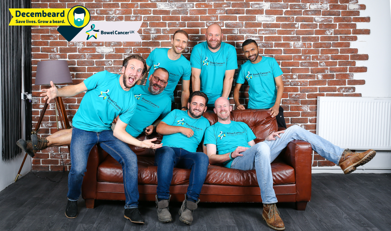 Men posing on sofa against brick wall 