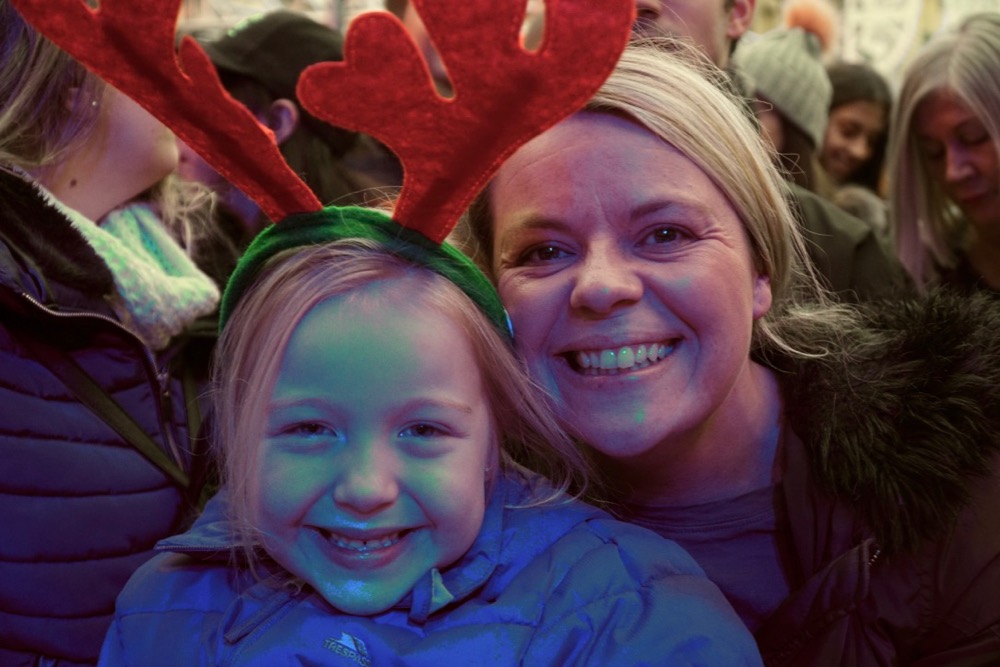 Wee girl wearing reindeer headband and her mum