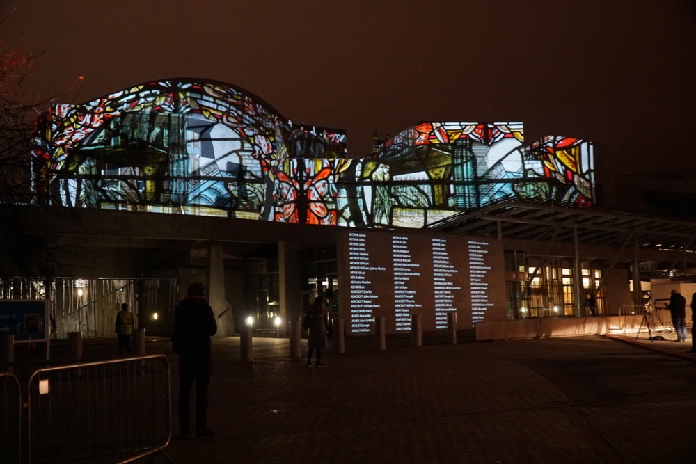 Scottish Parliament with projections illuminating the facade