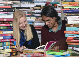 Two students surrounded by books