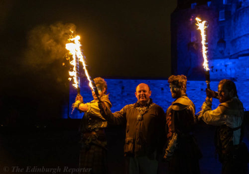 Four men with fiery swords in front of blue castle