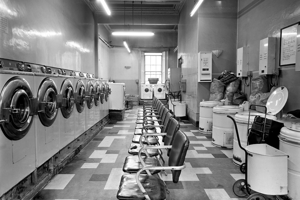Inside of launderette with two facing rows of washing machines