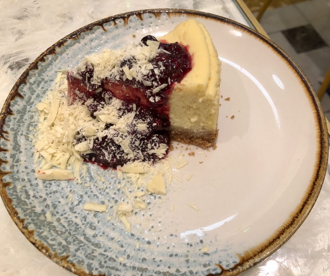 Baked cheesecake with fruit coulis and shards of white chocolate