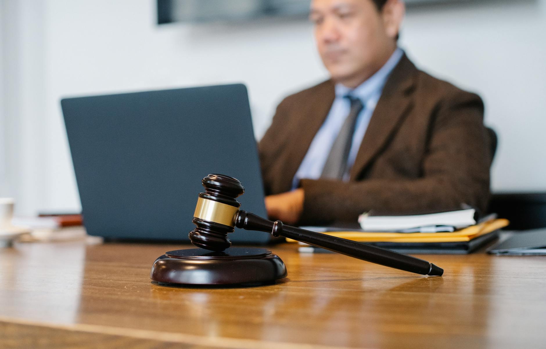 crop asian judge working on laptop in office